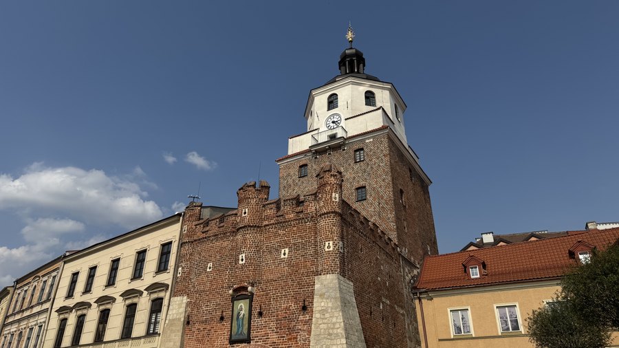 Gotycka Brama Krakowska z ceglanymi blankami i barokowym hełmem