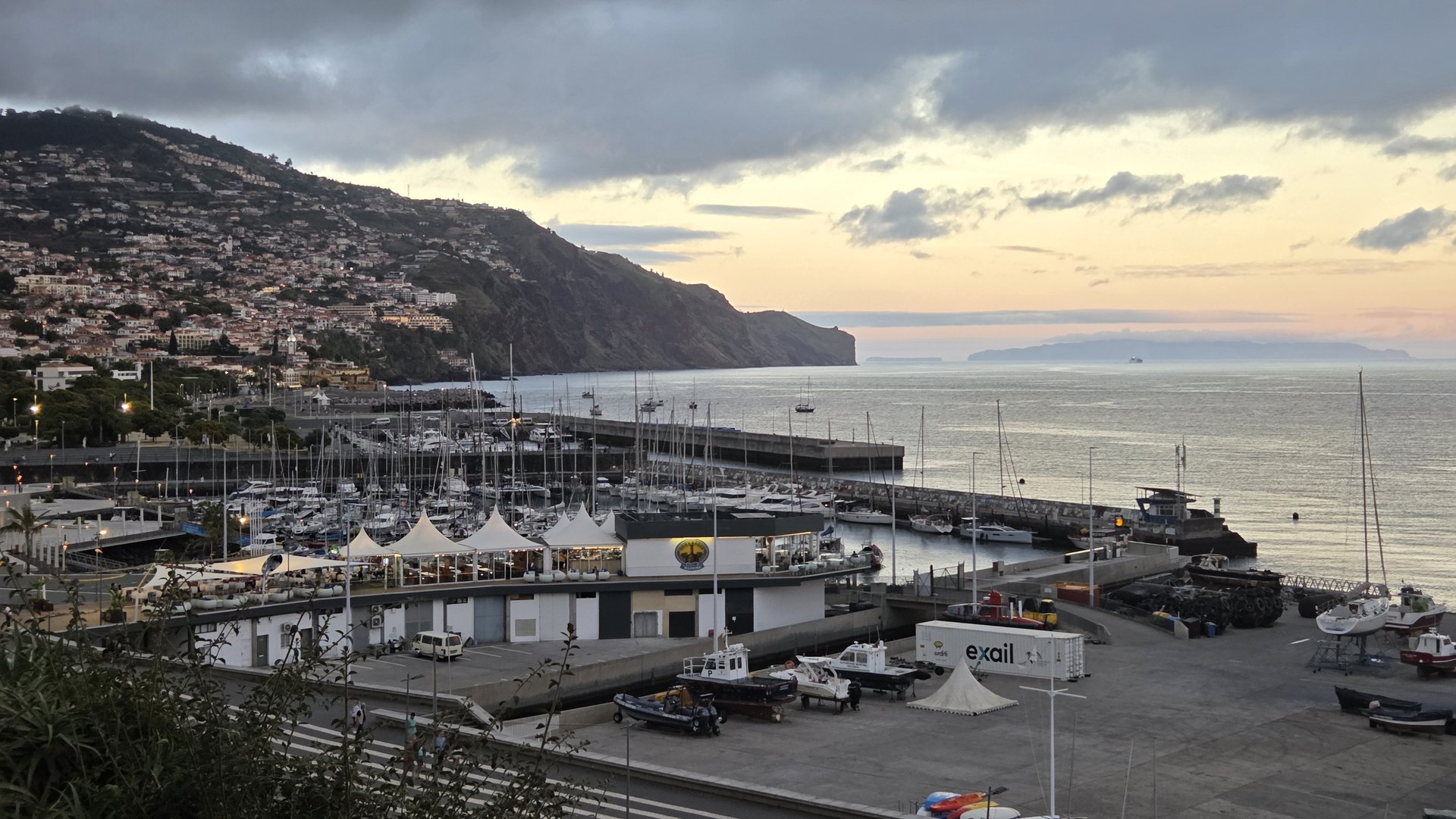 Marina w Funchal o zachodzie słońca, zabudowa na zboczach i ocean