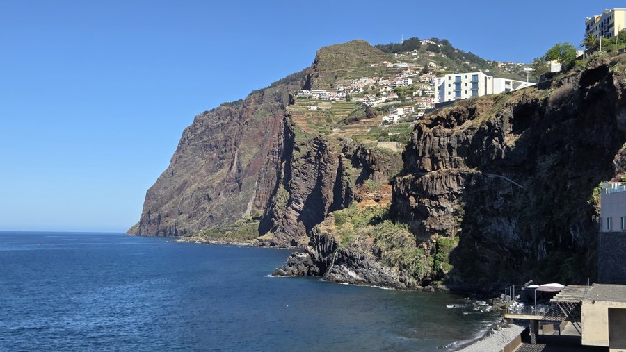 Klif Cabo Girão widziany z Câmara de Lobos nad spokojnym oceanem