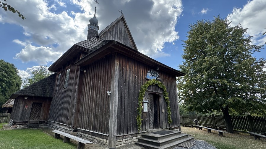 Drewniany kościół z wieżyczką i girlandą nad wejściem