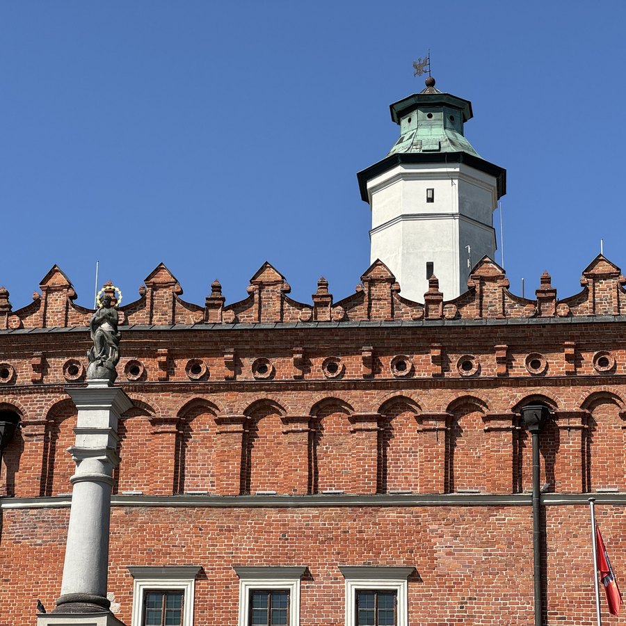 Renesansowa attyka ratusza w Sandomierzu z białą wieżą i figurą Matki Bożej na kolumnie